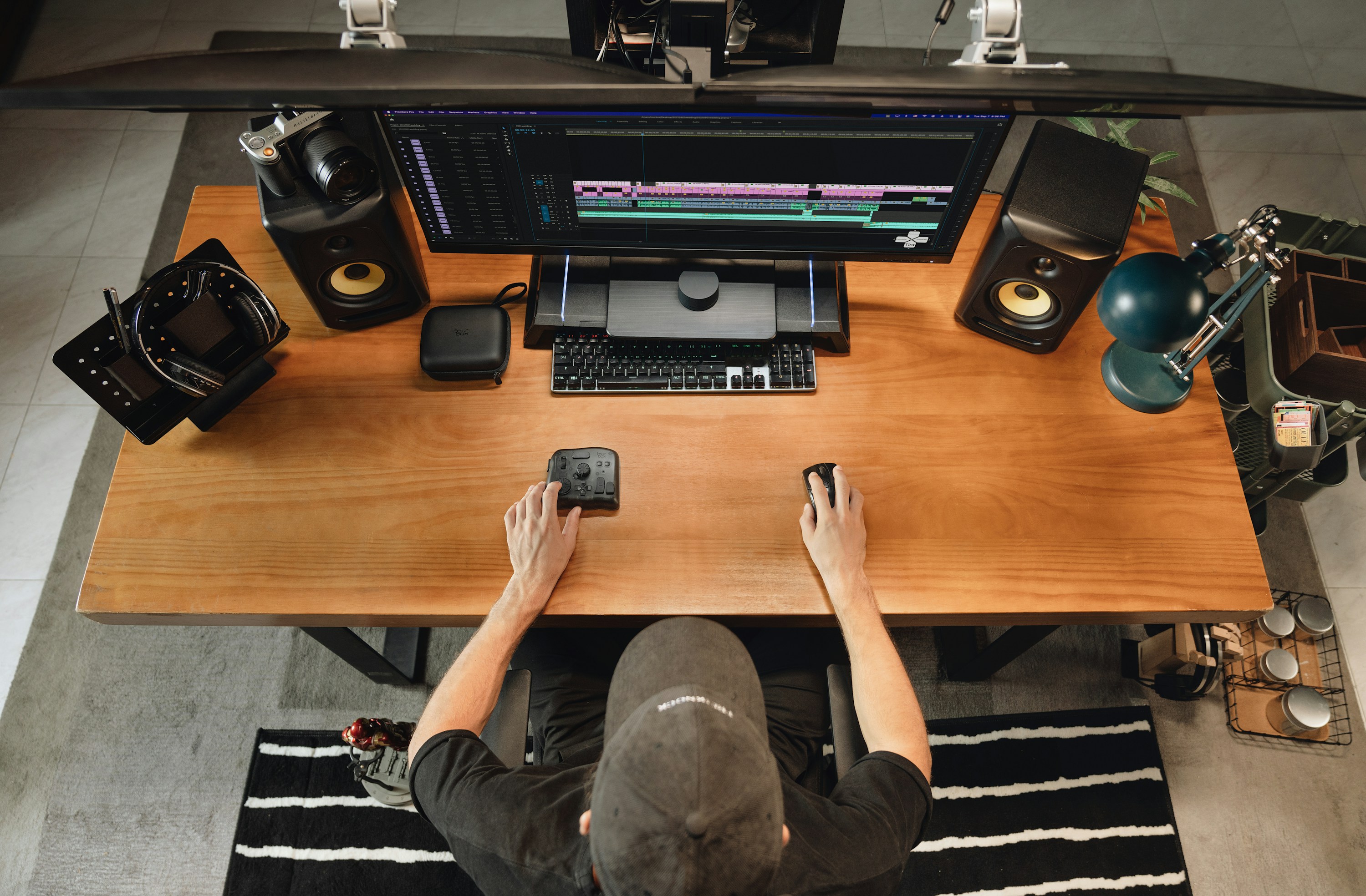 Video editor working at a workstation with a multitrack editing timeline.